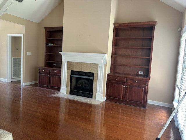 5901 Eastridge Pl, Mobile, AL 36608 - unfurnished living room with lofted ceiling, wood finished floors, a tiled fireplace, and baseboards