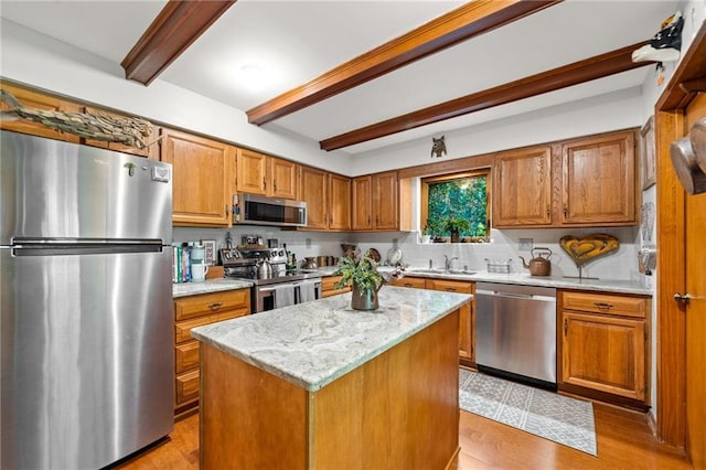 kitchen featuring light hardwood / wood-style floors, light stone countertops, beamed ceiling, a center island, and stainless steel appliances