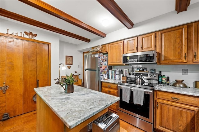 kitchen featuring beam ceiling, light hardwood / wood-style floors, light stone counters, a center island, and stainless steel appliances