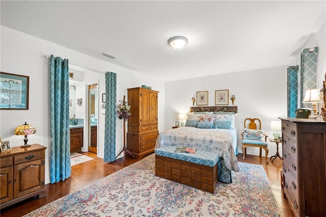 bedroom with wood-type flooring and ensuite bathroom