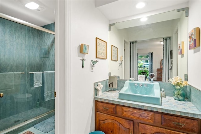 bathroom with a shower with door and vanity