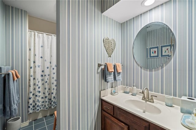 bathroom with tile patterned floors, walk in shower, and vanity