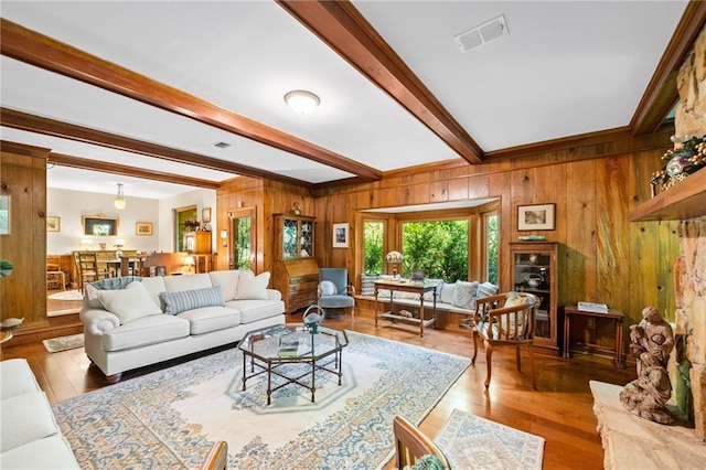 living room featuring beamed ceiling, hardwood / wood-style flooring, and wood walls