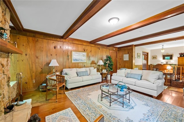 living room featuring beamed ceiling, wood-type flooring, and wooden walls