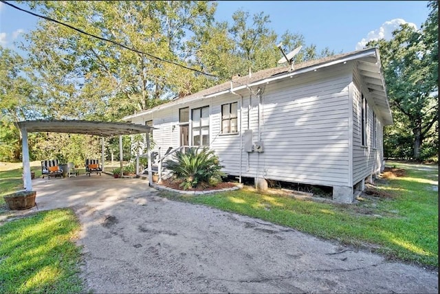 view of home's exterior featuring a lawn and a carport