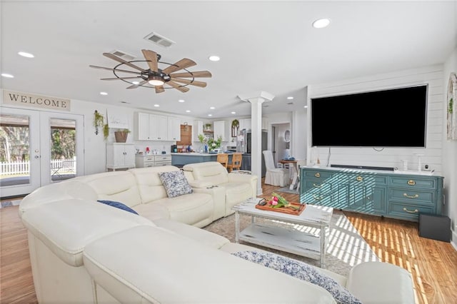 living area with french doors, decorative columns, recessed lighting, visible vents, and light wood-style flooring