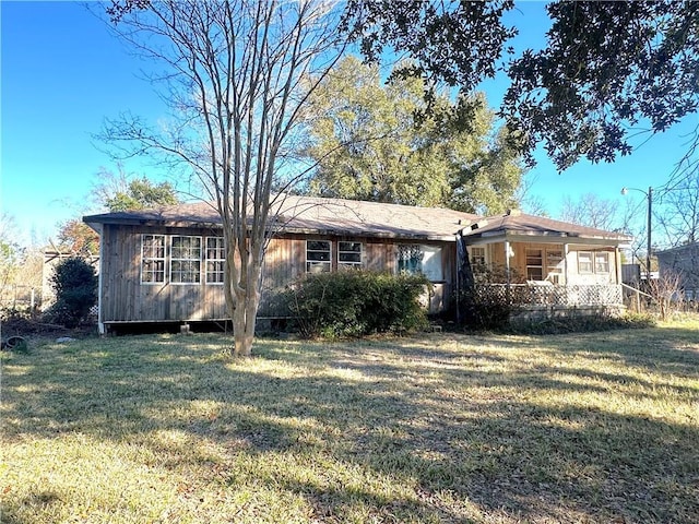 ranch-style home featuring covered porch and a front yard