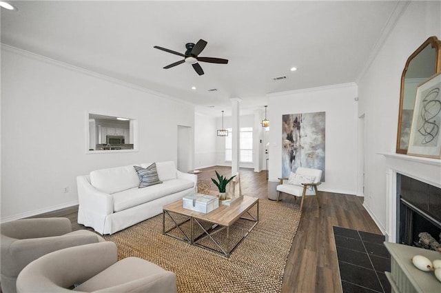 living room with dark wood-type flooring, ceiling fan, and crown molding