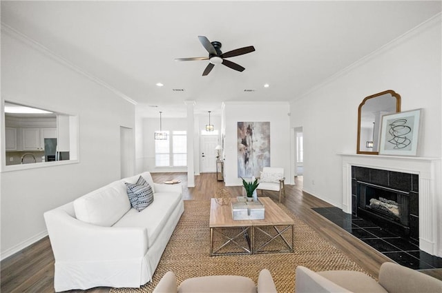 living room with crown molding, dark hardwood / wood-style floors, and a fireplace