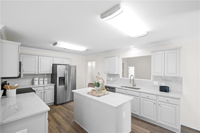 kitchen featuring a kitchen island, appliances with stainless steel finishes, sink, white cabinets, and decorative backsplash