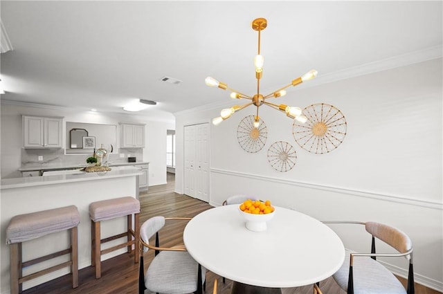 dining area with crown molding, dark hardwood / wood-style flooring, and a chandelier