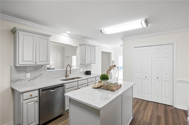 kitchen featuring sink, light stone counters, stainless steel dishwasher, ornamental molding, and a kitchen island