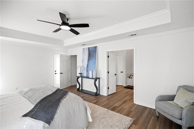 bedroom featuring ornamental molding, ceiling fan, dark hardwood / wood-style flooring, and a tray ceiling