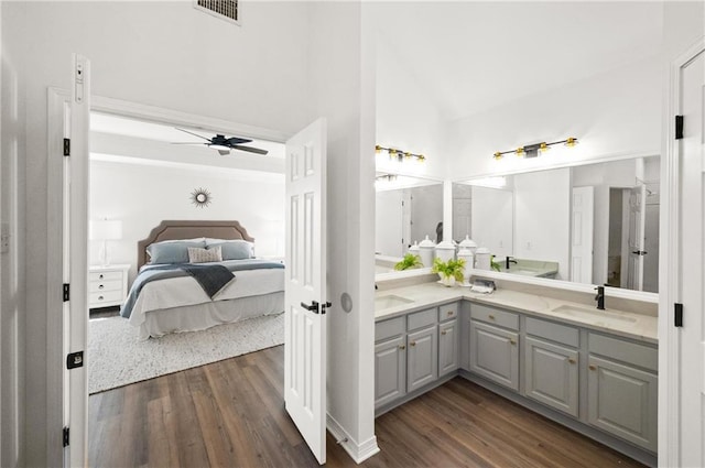 bathroom featuring vanity, high vaulted ceiling, hardwood / wood-style floors, and ceiling fan