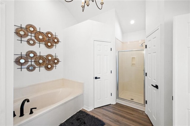 bathroom with independent shower and bath, wood-type flooring, and vaulted ceiling