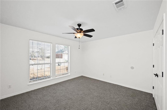 empty room featuring ceiling fan and dark colored carpet