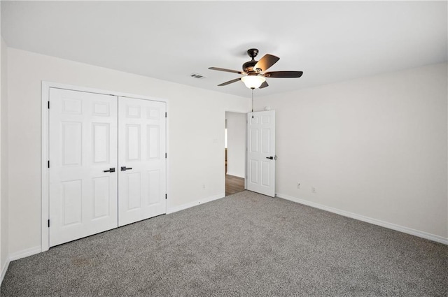 unfurnished bedroom featuring carpet, ceiling fan, and a closet