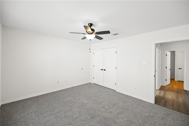 unfurnished bedroom featuring ceiling fan, dark carpet, and a closet