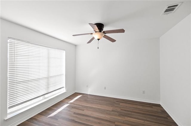 empty room featuring dark wood-type flooring and ceiling fan