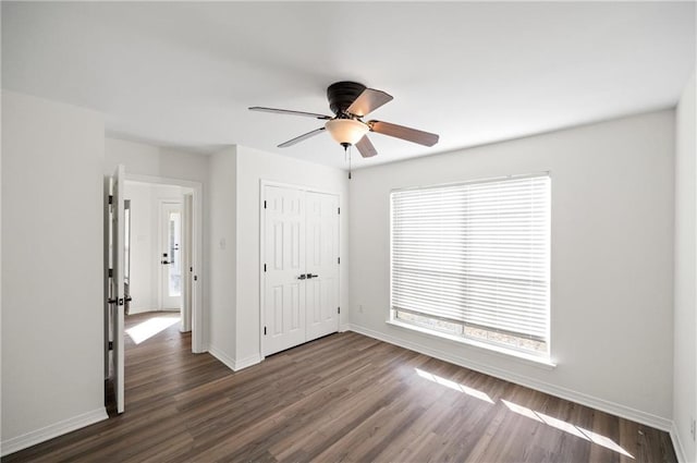 unfurnished bedroom featuring ceiling fan, dark hardwood / wood-style floors, and a closet