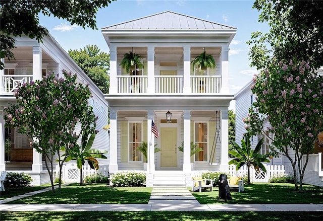 view of front of house featuring a balcony, a porch, and a front lawn