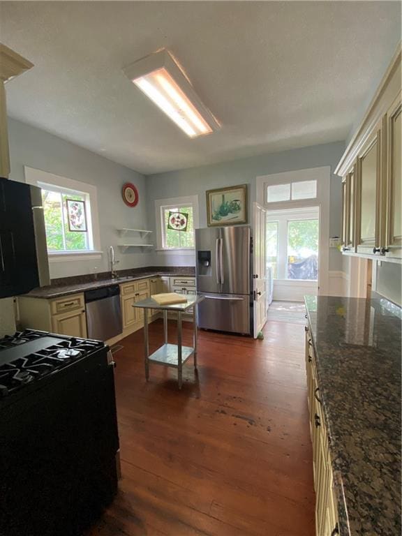 112 Kilmarnock St, Mobile, AL 36604 - kitchen featuring stainless steel appliances, cream cabinets, dark wood finished floors, and dark stone countertops