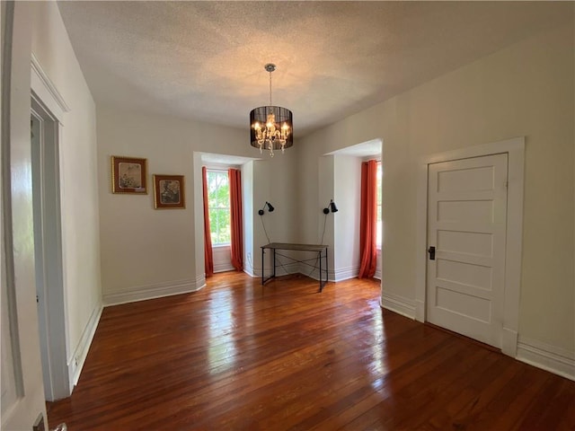 112 Kilmarnock St, Mobile, AL 36604 - empty room featuring a chandelier, dark wood-type flooring, baseboards, and a textured ceiling