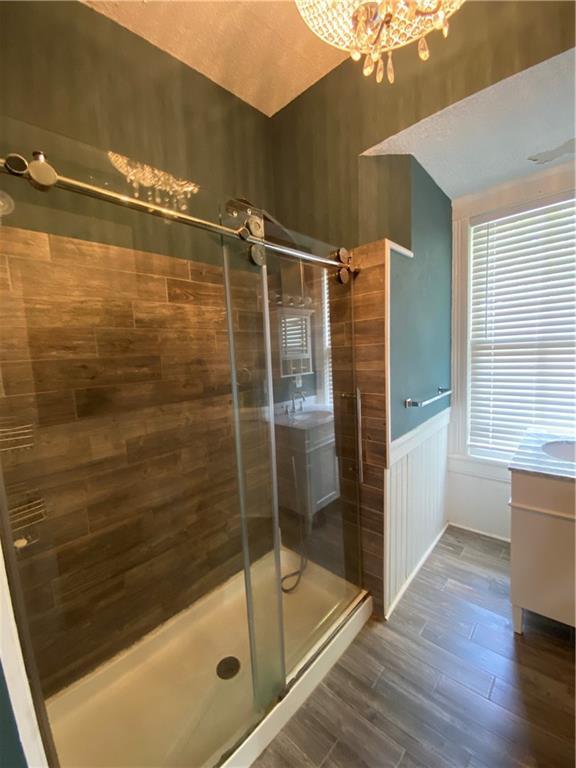 112 Kilmarnock St, Mobile, AL 36604 - bathroom featuring a stall shower, vanity, wood finished floors, a chandelier, and lofted ceiling
