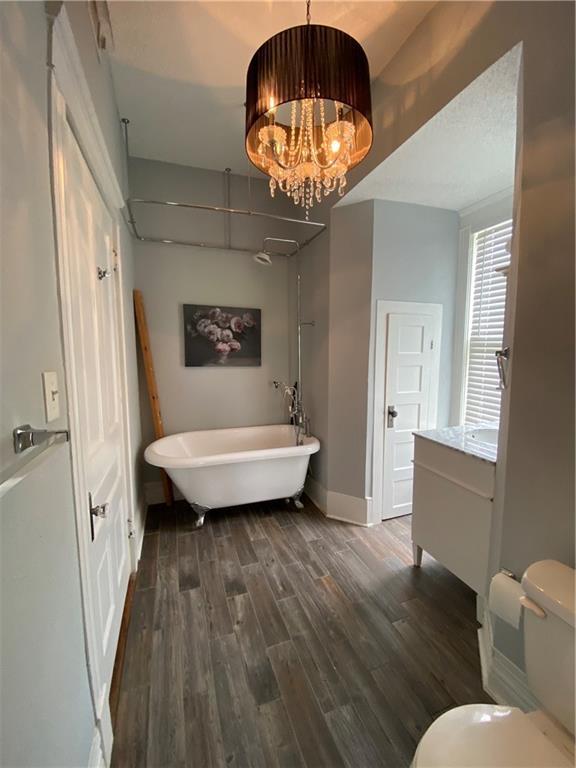 112 Kilmarnock St, Mobile, AL 36604 - full bathroom featuring a freestanding tub, vanity, baseboards, toilet, and wood finished floors