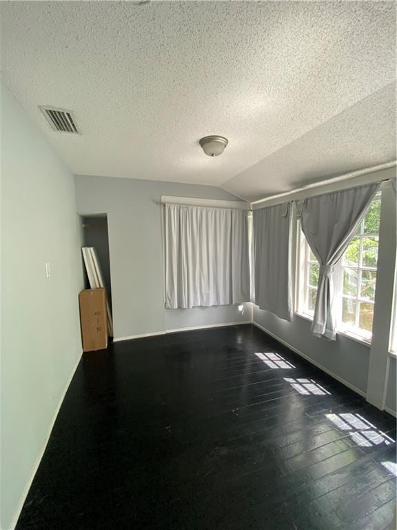 112 Kilmarnock St, Mobile, AL 36604 - spare room featuring a textured ceiling, baseboards, dark wood-type flooring, and vaulted ceiling