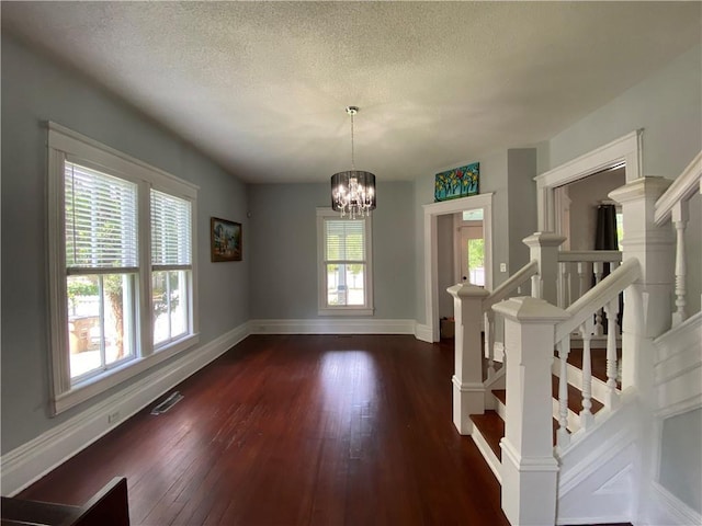 112 Kilmarnock St, Mobile, AL 36604 - spare room with baseboards, dark wood-style flooring, stairway, a chandelier, and a textured ceiling