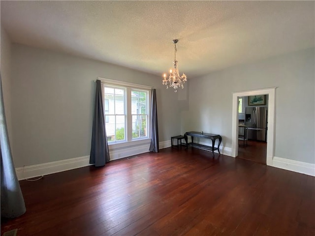 112 Kilmarnock St, Mobile, AL 36604 - unfurnished dining area featuring a chandelier, dark wood finished floors, baseboards, and a textured ceiling
