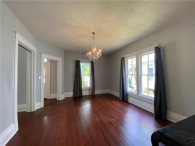 112 Kilmarnock St, Mobile, AL 36604 - unfurnished dining area with a chandelier, plenty of natural light, dark wood-type flooring, a textured ceiling, and baseboards