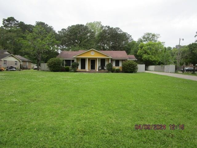 ranch-style home with a front yard and covered porch