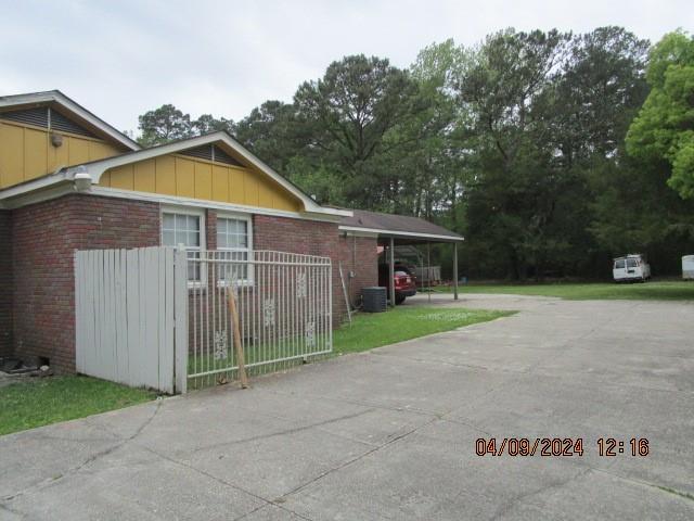 view of side of home featuring central AC and a carport