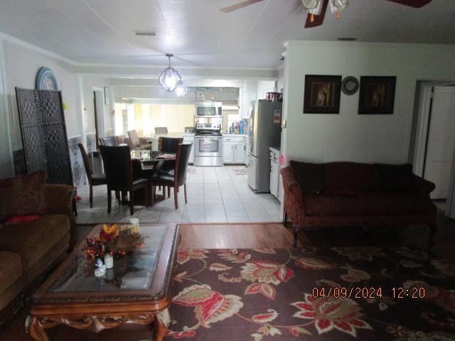 living room with ceiling fan and light wood-type flooring