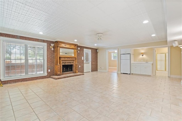 2605 Charleston Oaks Dr W, Mobile, AL 36695 - unfurnished living room featuring ceiling fan, a brick fireplace, crown molding, recessed lighting, and brick wall