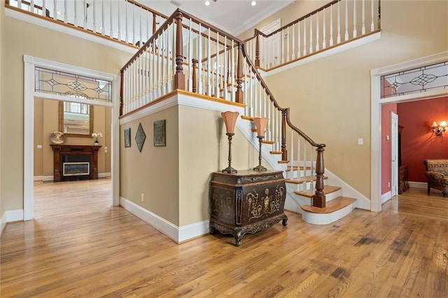 2605 Charleston Oaks Dr W, Mobile, AL 36695 - stairway featuring a high ceiling, wood finished floors, crown molding, a fireplace, and recessed lighting