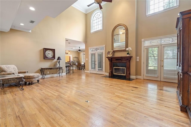 2605 Charleston Oaks Dr W, Mobile, AL 36695 - living area featuring ceiling fan, a high ceiling, healthy amount of natural light, light wood finished floors, and a fireplace with flush hearth