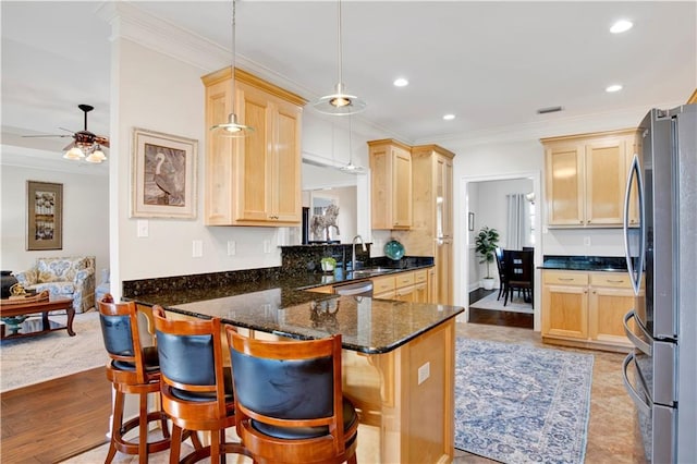 kitchen featuring hanging light fixtures, kitchen peninsula, appliances with stainless steel finishes, and a breakfast bar