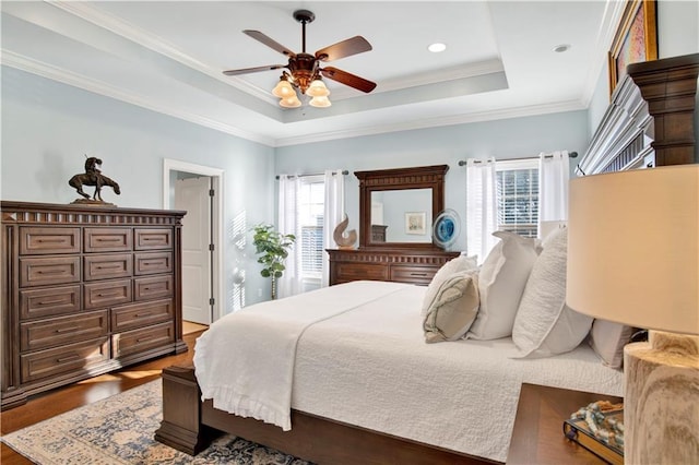 bedroom with ceiling fan, multiple windows, ornamental molding, and a raised ceiling