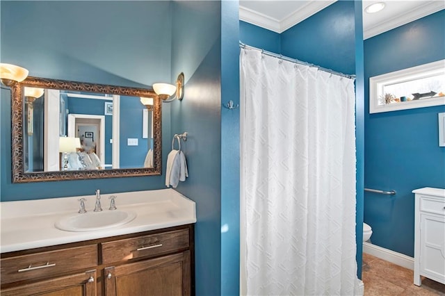 bathroom with toilet, vanity, and ornamental molding