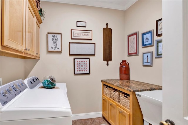 clothes washing area featuring washing machine and dryer, cabinets, sink, ornamental molding, and light tile patterned floors