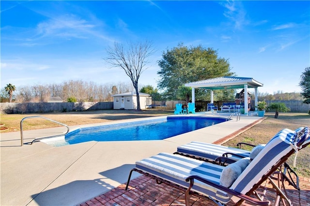 view of swimming pool featuring an outbuilding, a patio area, and a gazebo