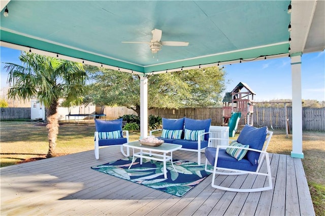 wooden deck featuring ceiling fan, a playground, and an outdoor hangout area