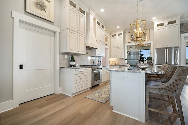 kitchen with dark stone countertops, white cabinets, stainless steel range, and a kitchen island