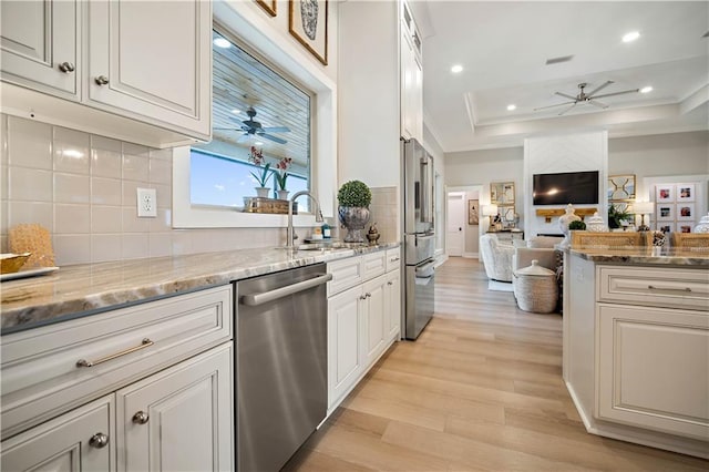 kitchen featuring white cabinetry, sink, stainless steel appliances, and light stone counters