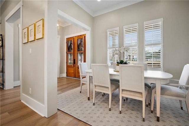 dining area featuring light hardwood / wood-style floors and ornamental molding