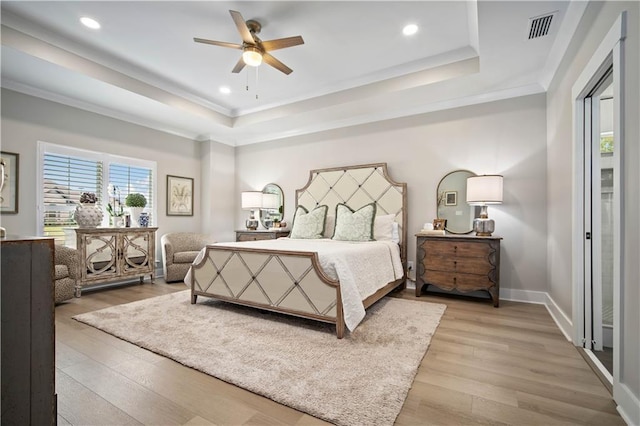 bedroom featuring a raised ceiling, ceiling fan, and wood-type flooring