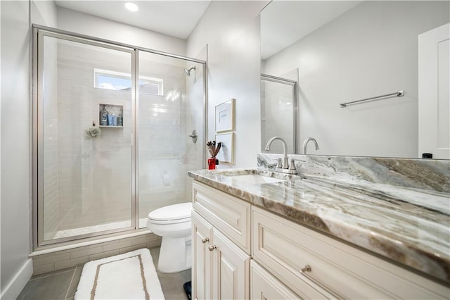 bathroom with tile patterned flooring, vanity, toilet, and a shower with shower door